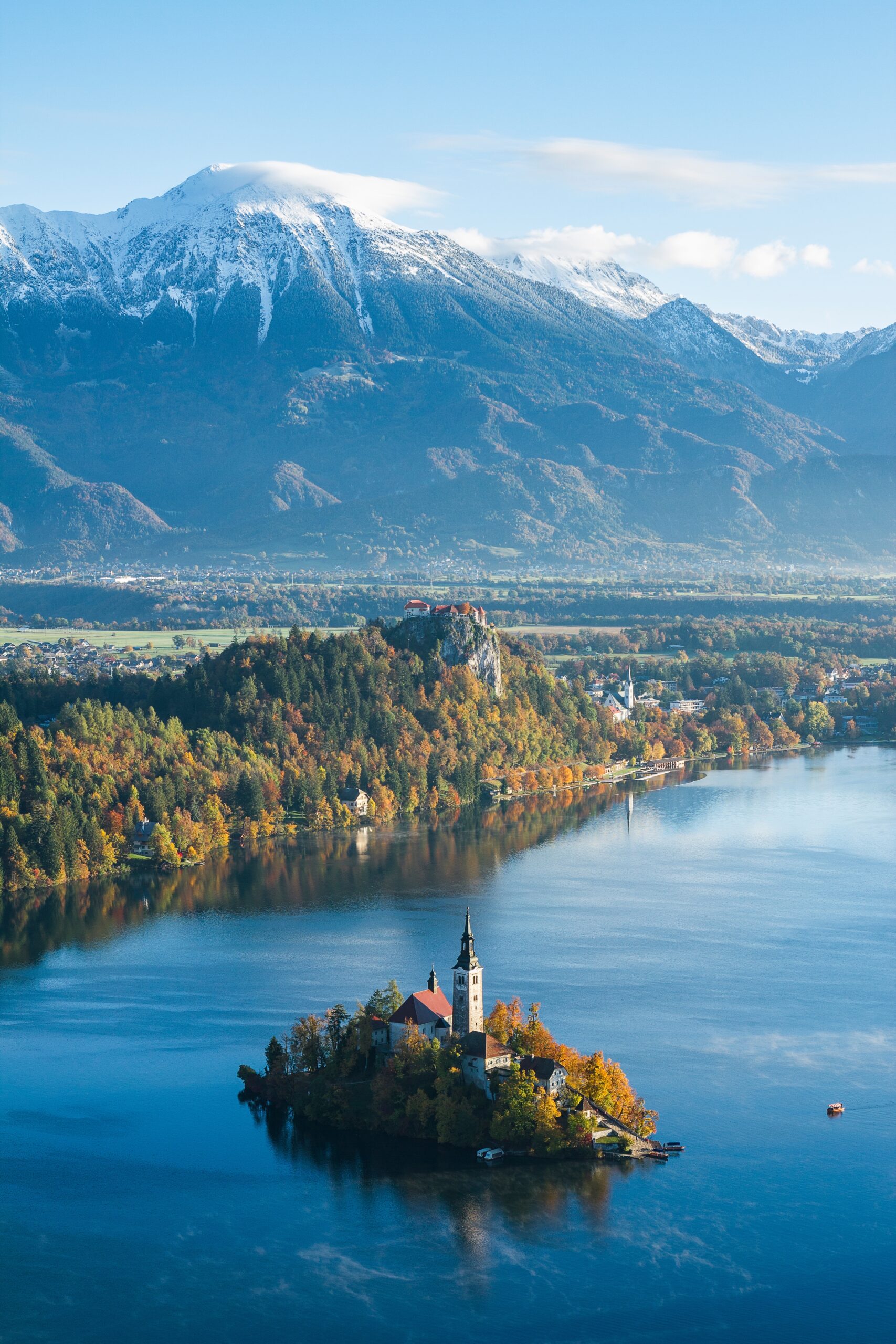 High angle shot of a building on a small island in Bled, Slovenia surrounded by high mountains